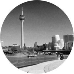 Person in Warnweste lehnt mit einem Klemmbrett an einem Geländer