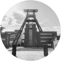 Person in Warnweste lehnt mit einem Klemmbrett an einem Geländer